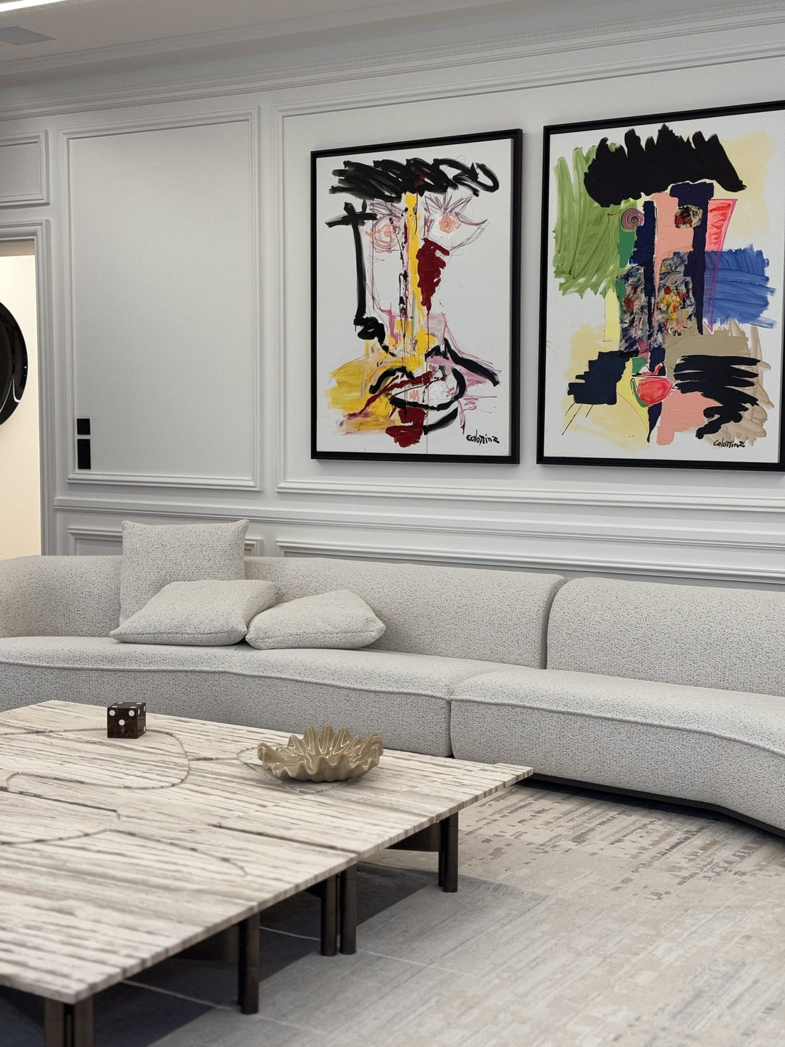 Séjour du duplex Maubourg : canapé courbe et grands formats encadrés sur boiseries